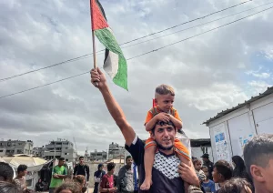 Palestinos comemoram no campo de Nusairat em 9 de outubro de 2025, após a notícia de um novo acordo de cessar-fogo em Gaza. Em 9 de outubro, Israel e o Hamas chegaram a um acordo de cessar-fogo em Gaza para libertar os reféns ainda vivos, um passo importante para o fim de uma guerra que matou dezenas de milhares de pessoas e desencadeou uma catástrofe humanitária. (Foto: Belal Abu Amer \ apaimages)