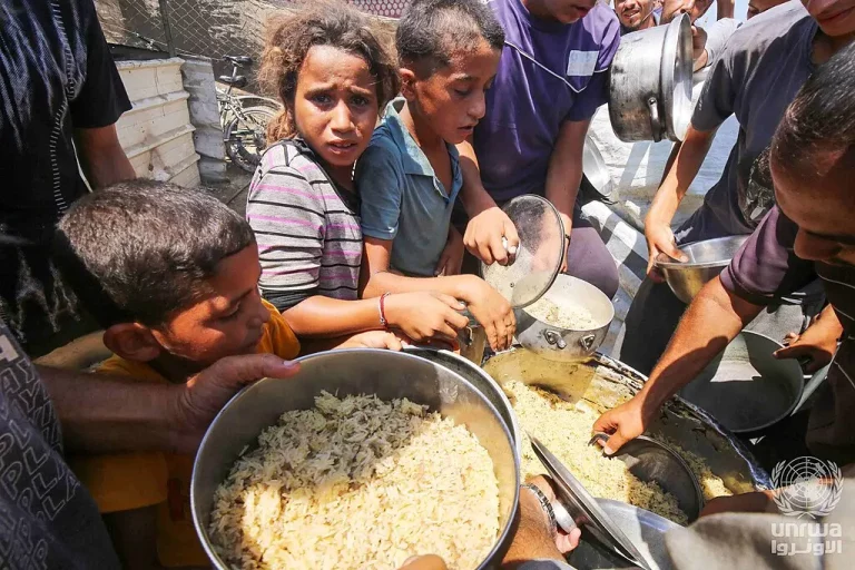 Crianças Palestinas em Deir el-Balah em uma fila para receber alimentaçã de organizações humanitárias. (Foto: Ashraf Amra / UNRWA)
