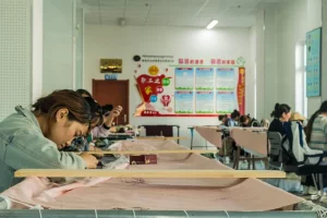 Jovem borda quadro ao estilo tibetano em oficina de bordados no condado de Gonghe. Salários vão de 4 a 8 mil yuans por mês. (Foto: Pedro Marin / Revista Opera / Opera Mundi)