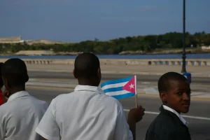 Um menino segura com orgulho a bandeira cubana durante um desfile militar em Havana, Cuba. (Foto: Thomassin Mickaël / Flickr)
