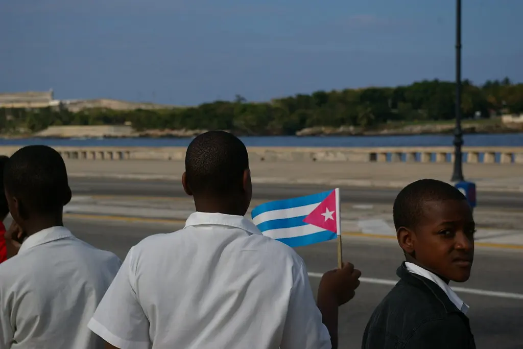 Um menino segura com orgulho a bandeira cubana durante um desfile militar em Havana, Cuba. (Foto: Thomassin Mickaël / Flickr)