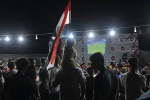 Palestinos assistem à partida entre Bélgica e Egito em Gaza. 15/06/2026. (Foto: Mazen Breem / Mondoweiss)